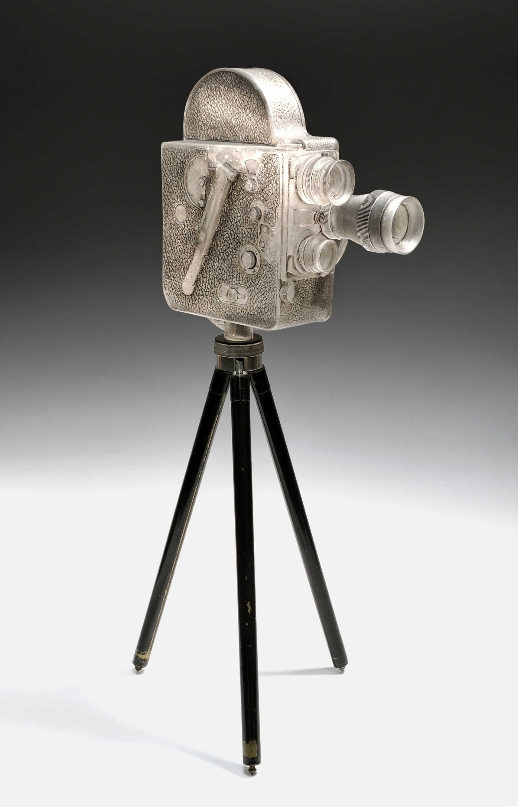 TITLE: “Bolex” DATE: 2014 MATERIAL: Glass, oil paint, Vintage Kodak tripod TECHNIQUE: Lost wax casting, acid etched, painted, polished SIZE: 9 x 9 x 25” (on tripod) PHOTO: John Mueller