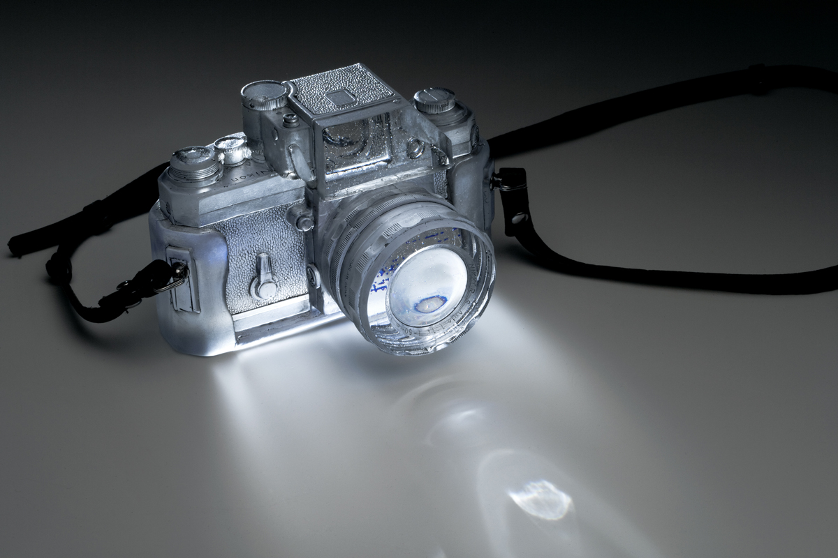 Title: “Dream Catcher” Materials: Glass, Paint, original leather strap, cast iron hook Technique: Cast glass, polished, etched, painted Size: 6”L x 4”w x 4”H (camera only without strap) Date: 2016 Photo: Douglas Sandberg